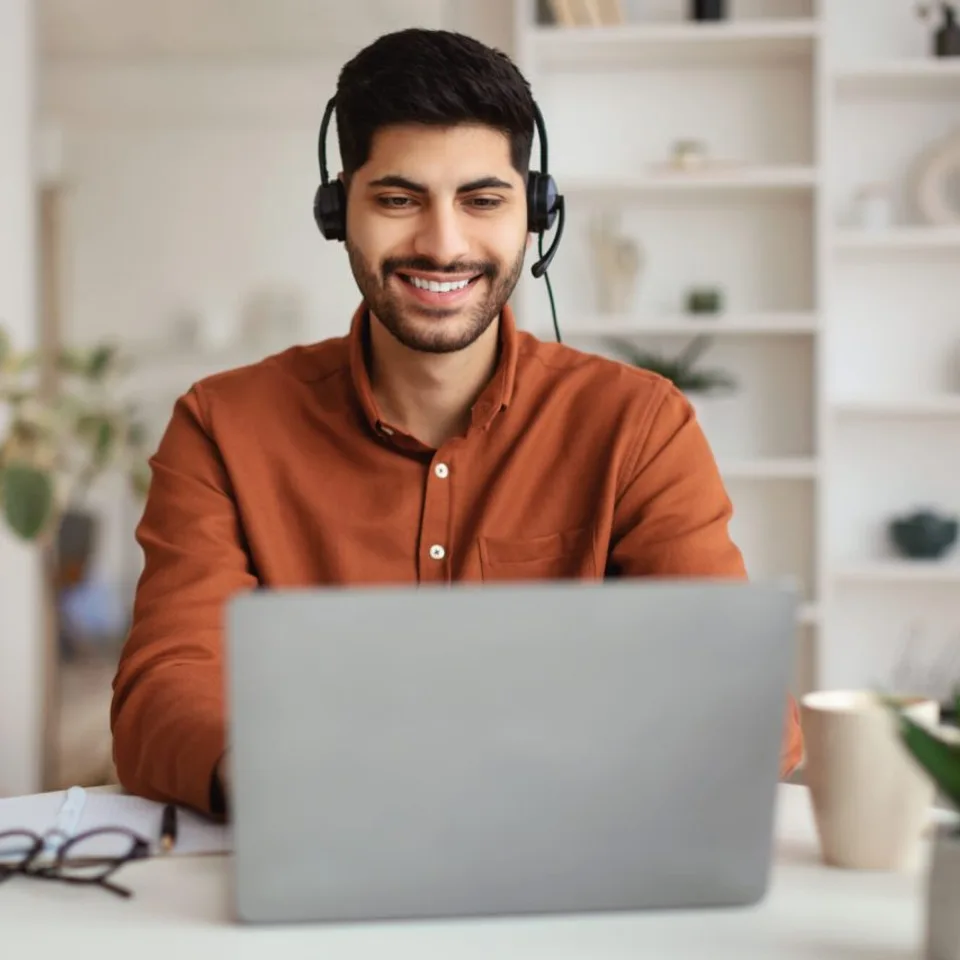 Atendimento remoto por videochamada, com uso de headset e computador